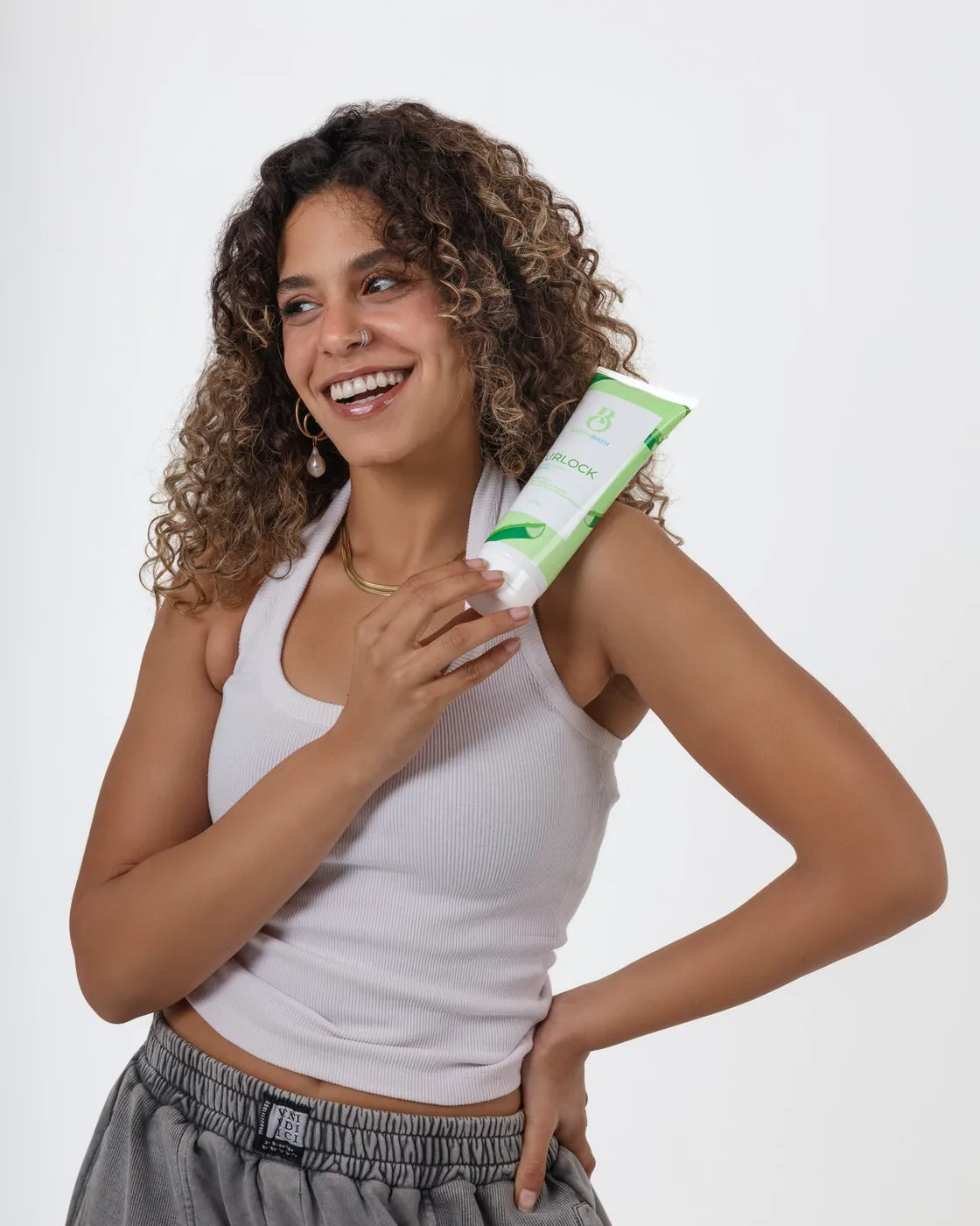 Model holding EarthBath Curlock styling gel